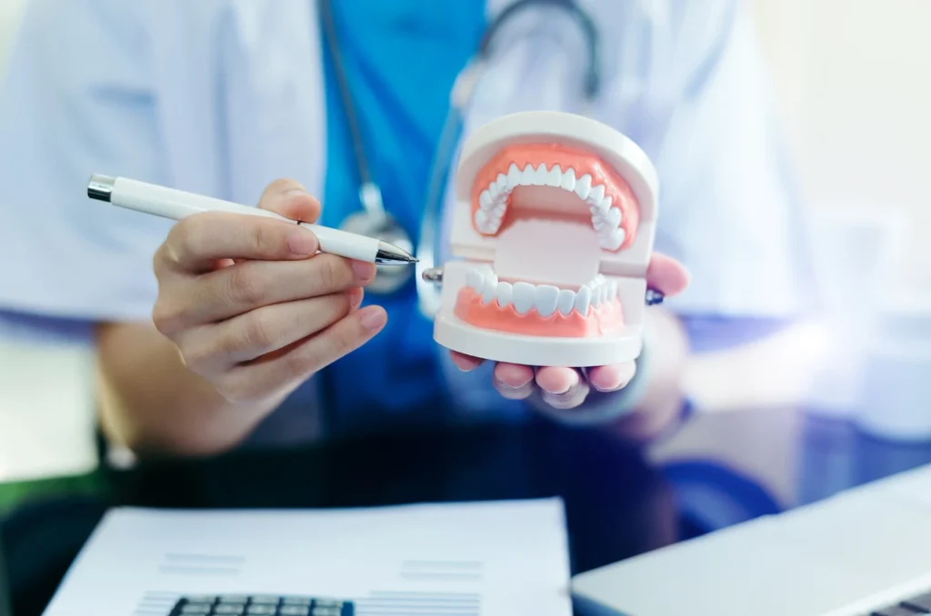 Dentista mostrando ao paciente uma protese dentaria Dentista mostrando ao paciente uma protese dentaria