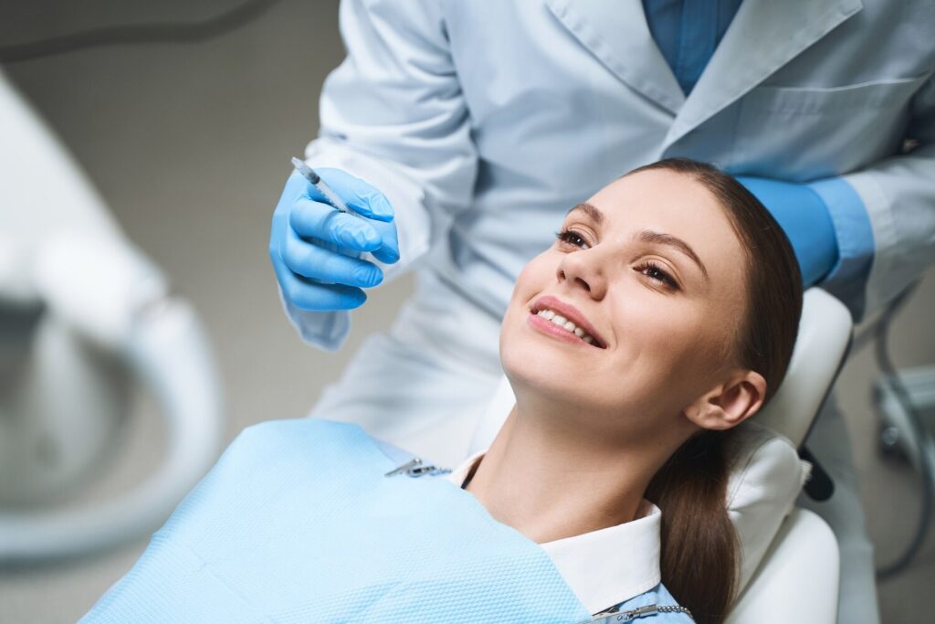 happy woman is lying dental chair preparing injection before tooth procedure 317809 5490 happy woman is lying dental chair preparing injection before tooth procedure 317809 5490