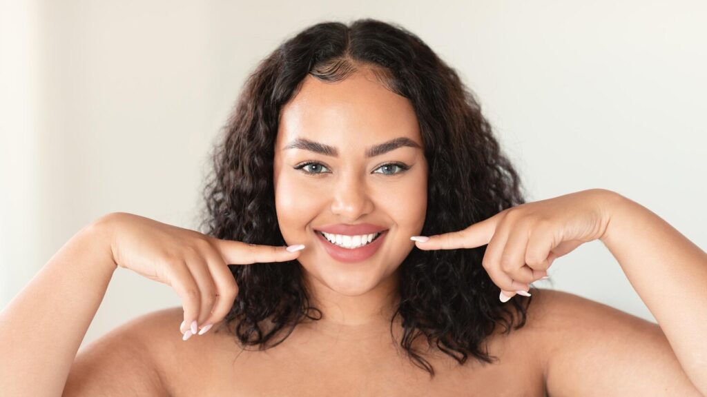 oral care concept beautiful plus size woman pointing her perfect smile with two fingers showing white teeth 116547 43833 oral care concept beautiful plus size woman pointing her perfect smile with two fingers showing white teeth 116547 43833